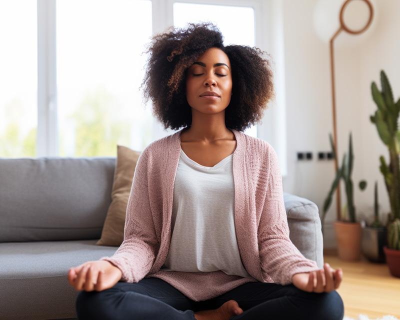Black woman doing mindfulness deep breathing to deal with chronic illness