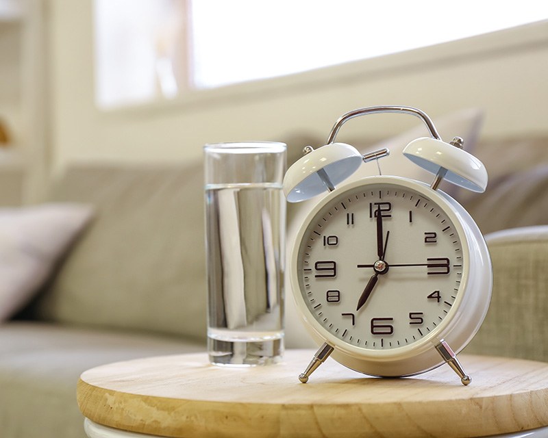 Clock and cup of water on a table; Get therapy for living with chronic illness in NY
